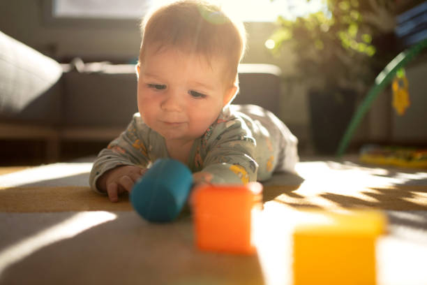 istock Front view of a curios baby boy playing on the floor 1306566795