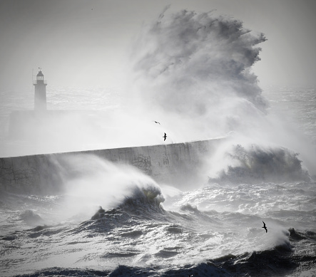 Giant waves with the force of the sea jumping Island and lighthouse.