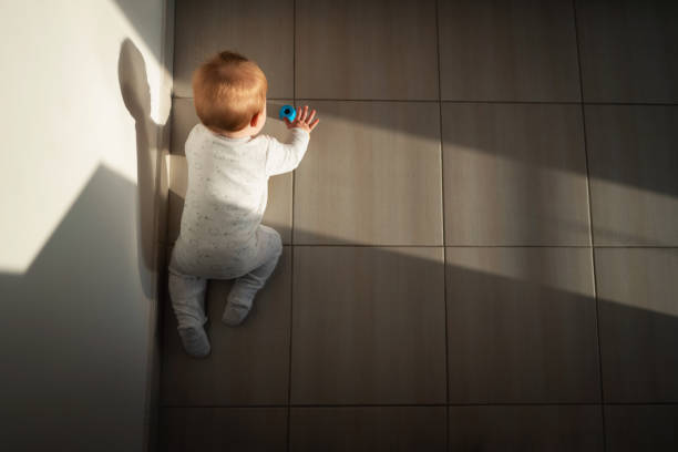 high angle view of a baby boy crawling - baby tile crawling tiled floor imagens e fotografias de stock