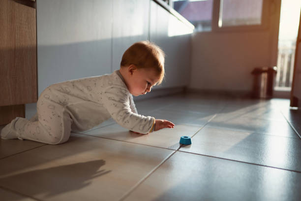 바닥에 장난감을 잡고 아기 소년의 측면 보기 - baby tile crawling tiled floor 뉴스 사진 이미지