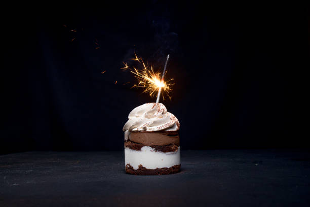 istock Chocolate and Raspberry Birthday Cake with Sparkler on Dark Background 1306567873