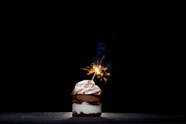 istock Delicious birthday cupcake with sparkler on dark table 1306567879