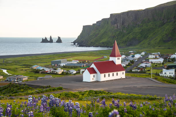 istock Small church overlooking a small coastal town 1306570096
