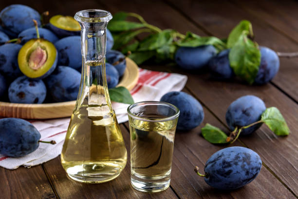 Plum brandy and fresh plums Plum brandy or schnapps in glasses and fresh tasty plums on a wooden table with copy space for text. Selective focus. serbian raki stock pictures, royalty-free photos & images