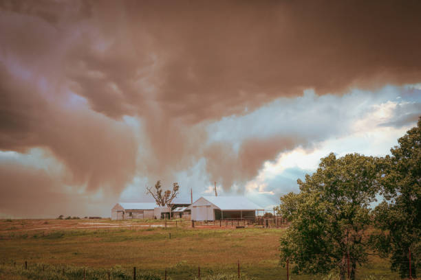 Onimous looking dust storm blowing in over western Oklahoma farm with barns and pasture. stock photo