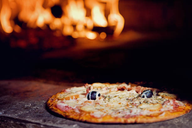 istock Italian pizza in a fire oven 1306573876
