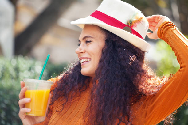 istock Beautiful young woman drinking orange juice 1306585004