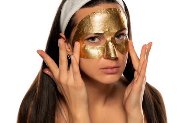 istock young woman posing with golden mask on her face 1306586155
