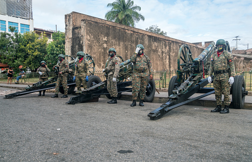 March 9, 2021 Santo Domingo, Dominican Republic. Soldiers standing to attention next to a cannon in the colonial district of the capital city.