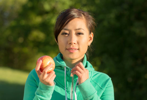 happy woman with apples in her hands in nature Green grass trees Summer sun. High quality photo