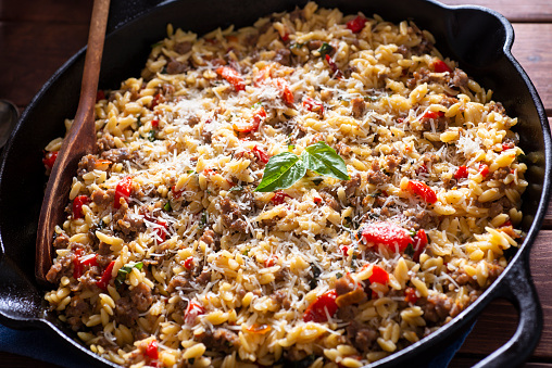 One-skillet Meal with Orzo, Italian Sausage, Roasted Red Pepper, Cherry Tomatoes, Parmesan Cheese and Basil.