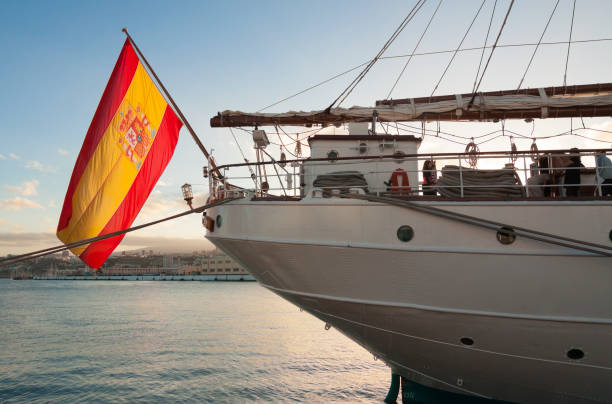 Spanish national flag set on tall ship at Las Palmas port. Gran Canaria, Canary, Spain Spain - Canary - Gran Canaria - The bright red and yellow spanish national naval stern flag set on the abstract tall ship moored at Las Palmas port at dusk gaff rigged stock pictures, royalty-free photos & images