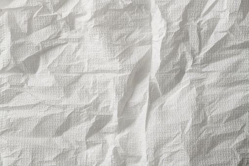 Overhead shot and close-up of wrinkled white paper napkin texture background.