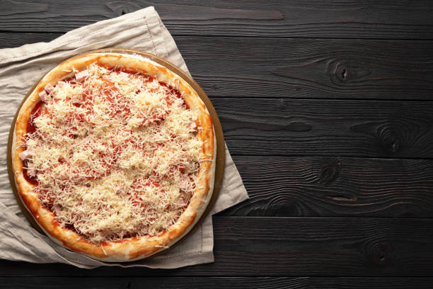 pizza ready for the oven on a wooden background, place for text, top view. stock photo