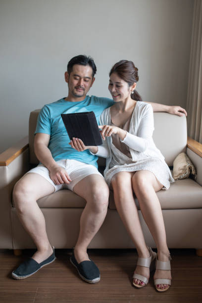 istock Couple looking at digital tablet together on a couch 1306617483