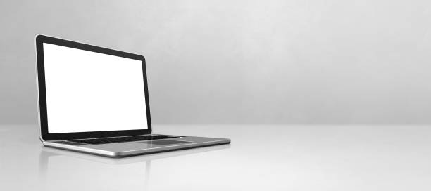 istock Laptop computer on white concrete office scene background banner 1306617551