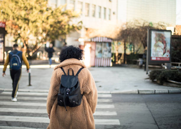 istock Woman crossing the road. 1306620511