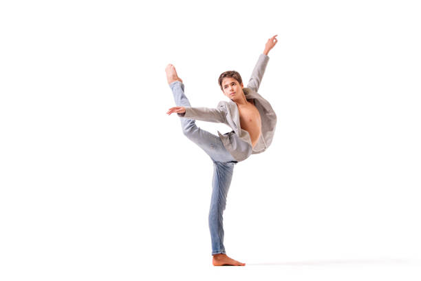 teenage ballet dancer poses barefoot, isolated on white background.