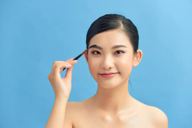 istock woman applying eyeshadow on eyelid using makeup brush 1306622164
