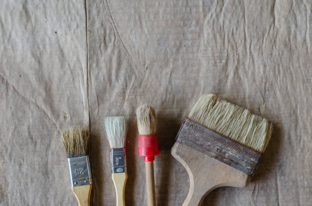 istock Old paint brushes on a dirty cardboard surface. 1306623282