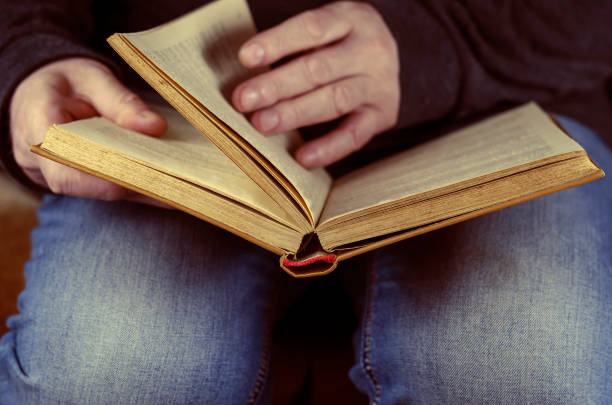 istock An open book lies at the man's feet. 1306623319
