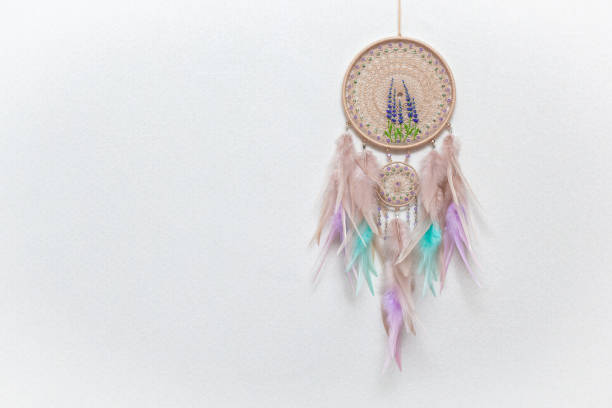 istock Handmade dream catcher with feathers threads and beads rope hanging on white background 1306627951