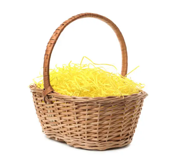 Easter basket with yellow paper filler isolated on white