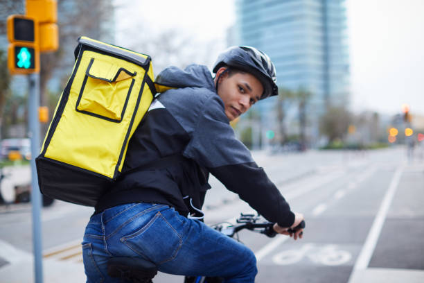 istock A delivery person looking backward from his bicycle. 1306630994
