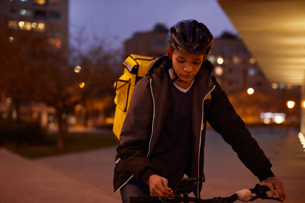 istock Delivery rider at dusk looking at the smartphone. 1306631021