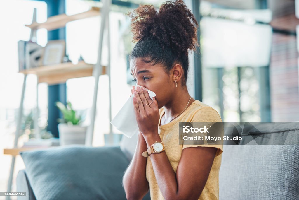 A day of rest is the route to recovery Shot of a young woman feeling ill on the sofa at home Allergy Stock Photo