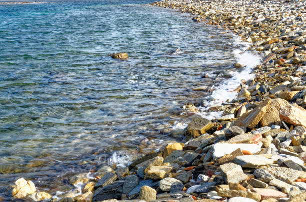 The Atlantic Ocean covering a rocky beach at Playa de las Americas which is a popular tourist location on the south coast of the Spanish Canary Island Tenerife.