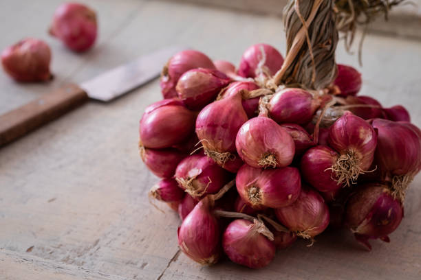 istock Bunch of shallot on wooden table 1306634094