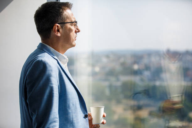 istock Mature businessman having coffee by the window 1306638942