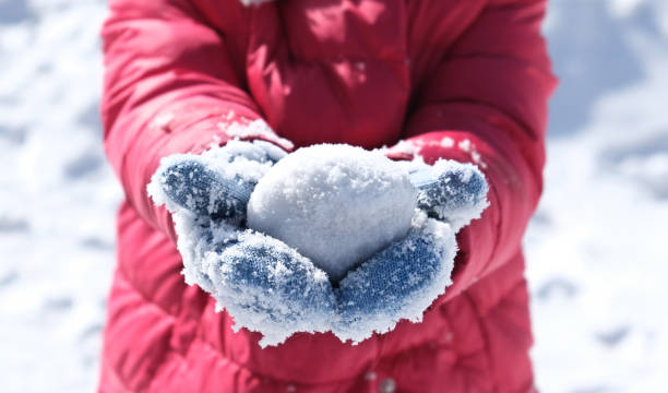 Snowball in frosty mittens on the hands of a child Snowball in frosty mittens on the hands of a child, The concept of snow games and fun. Walk outdoor snowball stock pictures, royalty-free photos & images