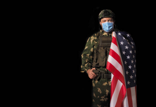 istock US Military man with face mask on black background. 1306640432