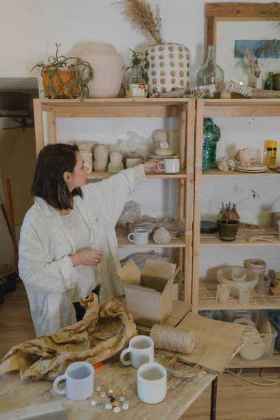istock Female ceramist packing orders in her studio 1306640560