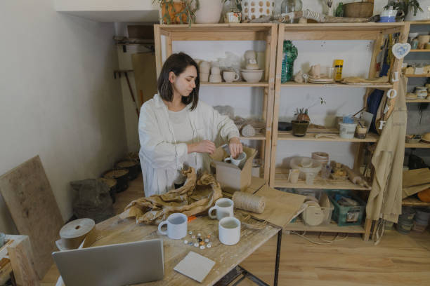 istock Female ceramist packing orders in her studio 1306640564