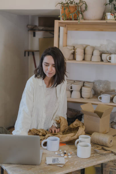 istock Female ceramist packing orders in her studio 1306643738