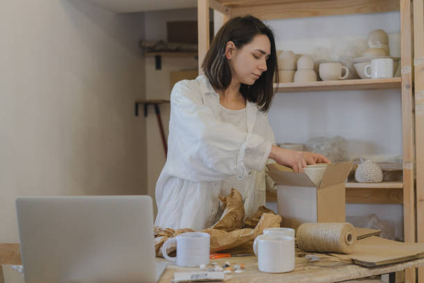 istock Female ceramist packing orders in her studio 1306643773