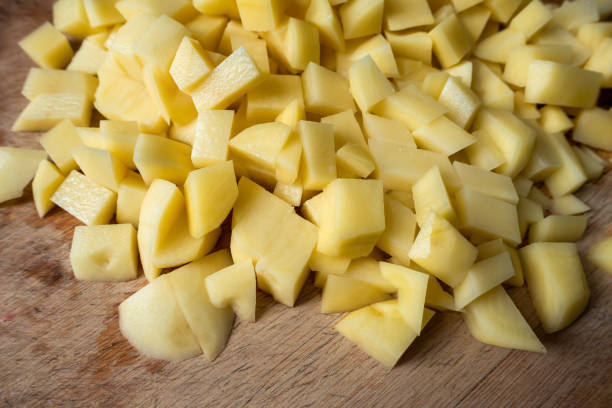 istock Fresh potatoes on wooden kitchen board 1306646363