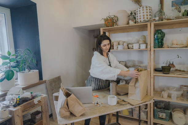istock Female ceramist packing orders in her studio 1306647455