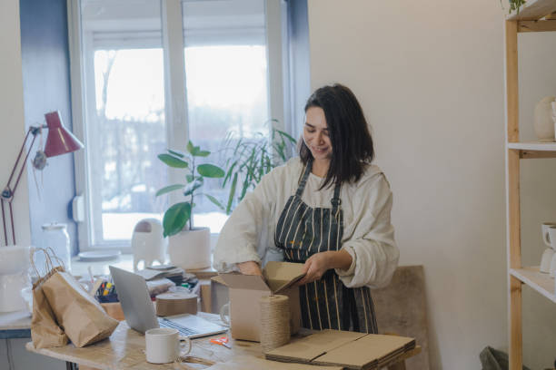 istock Female ceramist packing orders in her studio 1306647463