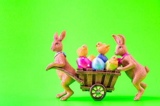 istock Two Easter bunnies with a cart full of Easter eggs and chicks 1306647678