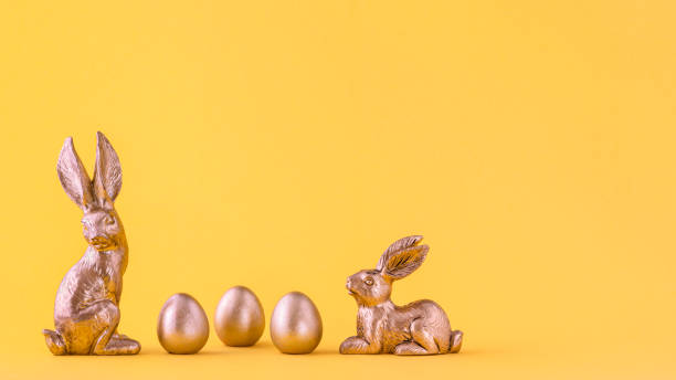 istock Two gold bunnies with three gold eggs 1306647729