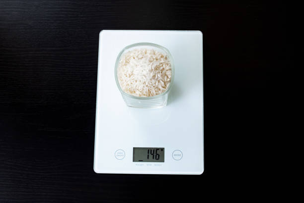istock Glass with rice on electronic scales on wooden table 1306650308