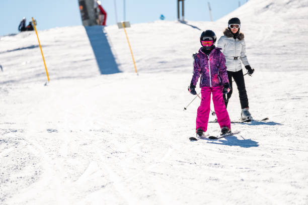istock Mother and daughter on ski slope 1306650309