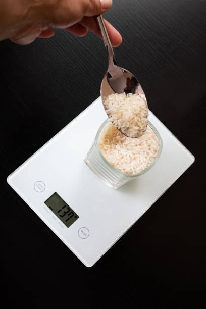istock Glass with rice on electronic scales and spoon 1306650310