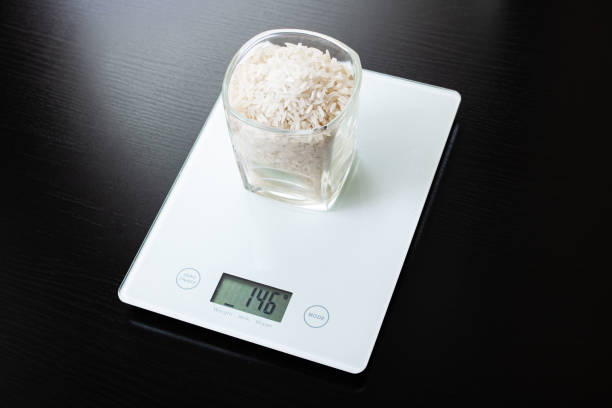 istock Glass with rice on electronic scales on wooden table 1306650311