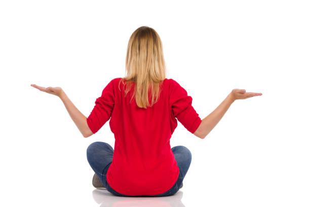 istock Young Woman Is Sitting On A Floor, Holding Hands Raised And Comparing. 1306650725