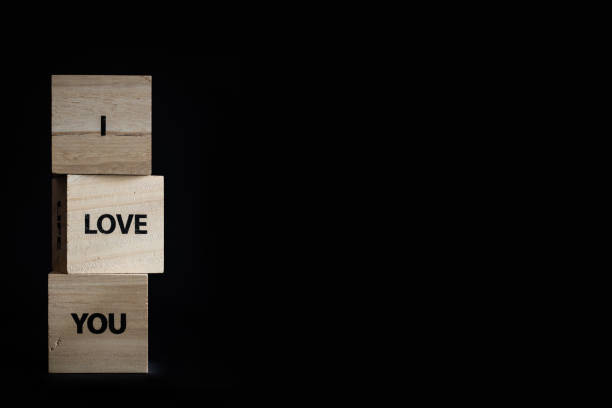istock Three wooden cubes black background - I love you message 1306652836